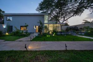 a large white house with a garden in front of it at Finca Estrella de ASIA in Mérida