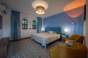 a bedroom with a bed and a couch and a chair at Finca Estrella de ASIA in Mérida +33 photos