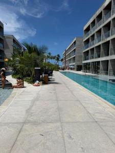 a swimming pool in a building with people sitting next to it at Gav Resorts in Ipojuca