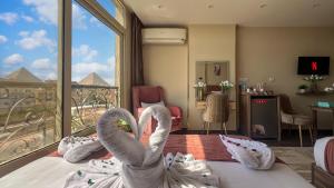 two swans sitting on a bed in a hotel room at Hammis Pyramids View INN in Cairo
