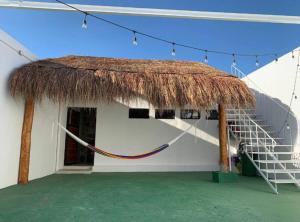 a building with a thatch roof and a staircase at Departamento comodo en Progreso 1 Recamara 3 personas in Progreso