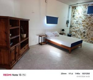 a bedroom with a bed and a wooden cabinet at Departamento comodo en Progreso 1 Recamara 3 personas in Progreso