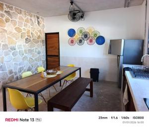 a kitchen with a wooden table and yellow chairs at Departamento comodo en Progreso 1 Recamara 3 personas in Progreso