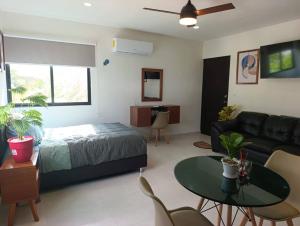a bedroom with a bed and a couch and a table at Loft Elegante Comodo 2 personas in Mérida