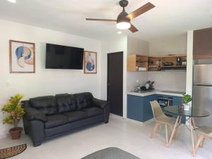 a living room with a couch and a kitchen at Loft Elegante Comodo 2 personas in Mérida +21 photos