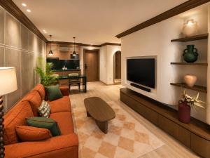 a living room with a orange couch and a television at NOMA New Cairo in New cairo