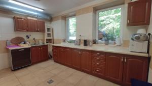 a large kitchen with wooden cabinets and a window at Villa Góralka in Polanica-Zdrój