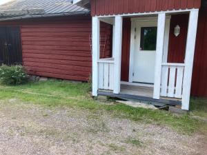a red and white house with a white door at Liten lägenhet i Öje in Öje
