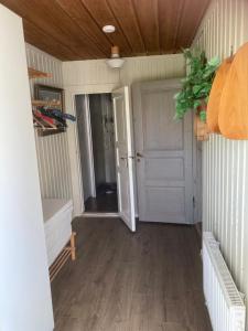 a hallway with a white door and a wooden floor at Liten lägenhet i Öje in Öje