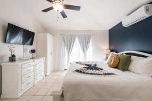 a bedroom with a bed and a ceiling fan at Coco Garden Suites in Coco