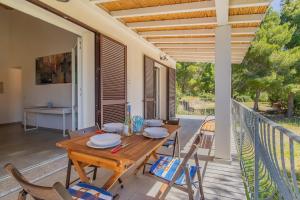 a wooden table and chairs on the deck of a house at Villa Artistica in Trappola