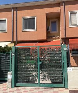 a green fence in front of a building at Monolocale Zefiro in Elmas