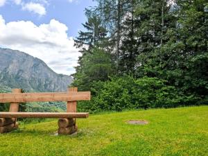 a wooden bench sitting on top of a green field at Chalet Mélèze 1967 by Interhome in Ovronnaz