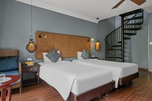 a bedroom with a large white bed and a staircase at Sweet Daisy Retreat in An Bàn (2)