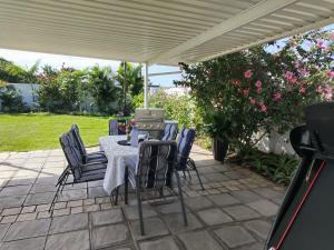 a table and chairs under a white umbrella at Eluthando Guesthouse in St Lucia