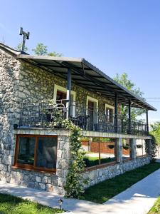 a stone house with a balcony on top of it at Konoba Stanisic in Balabani