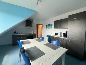 a kitchen with a white table and blue chairs at Monteur-Pension W8 in Bad Schmiedeberg
