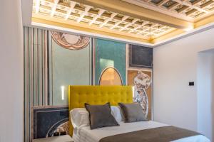 a bedroom with a bed with a yellow headboard at Relais Villa Flora Berta in Matelica