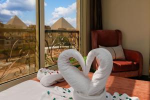 a room with swan towels on a table in front of a window at Hammis Pyramids View INN in Cairo +97 photos