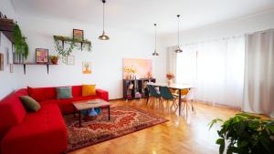 a living room with a red couch and a table at Casa Magenta - Alojamento Local in Trofa