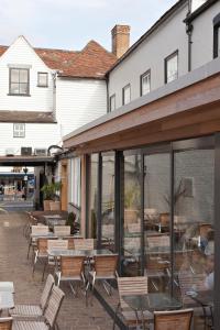 an outdoor patio with tables and chairs and windows at The Penny Farthing Hotel in Berkhamsted
