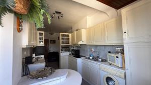 a kitchen with white cabinets and a sink at Casa Nautica in Paço de Arcos