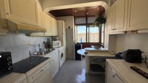 a kitchen with white cabinets and a sink at Casa Nautica in Paço de Arcos
