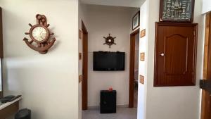 a hallway with a clock and a tv on a wall at Casa Nautica in Paço de Arcos +9 photos
