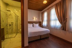 ein Schlafzimmer mit Bett und Glasdusche in der Unterkunft Armistis Hotel in Mudanya