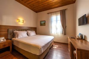 ein Hotelzimmer mit einem Bett und einem Fenster in der Unterkunft Armistis Hotel in Mudanya