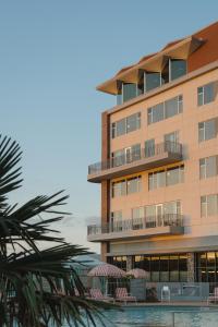 a building with chairs and a pool in front of it at Caravan Court Hotel in Arlington