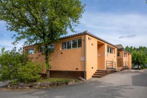 a house with a tree in front of it at Camping Bungalow el Llac de Banyoles in Porqueres