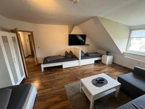 a living room with a couch and a tv at Monteur-Pension W8 in Bad Schmiedeberg