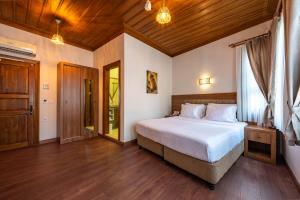 ein Schlafzimmer mit einem großen Bett und einer Holzdecke in der Unterkunft Armistis Hotel in Mudanya + 48 Fotos