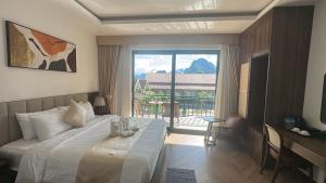 a hotel room with a bed and a large window at Sunset Mountain View Resort in Vang Vieng +59 photos