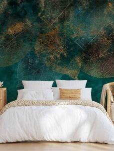 a bedroom with a bed with a leafy wall at Le murmure des pins in Villemoustaussou