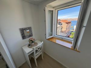 a small white table and a window in a room at Apartment BELLA in Karlobag