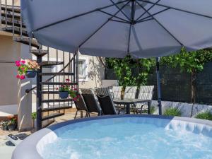 a hot tub with chairs and an umbrella at Apartment L&V by Interhome in Galižana