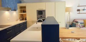 a kitchen with a sink and a table and a microwave at Calella-Port Bo · Sun Sea Unique Character in Calella de Palafrugell
