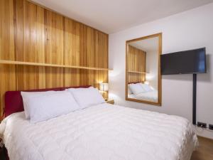 a bedroom with a large white bed and a mirror at Apartment Villa Adele by Interhome in Madesimo