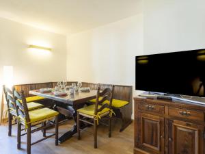 a dining room with a table with chairs and a flat screen tv at Apartment Villa Adele by Interhome in Madesimo +21 photos