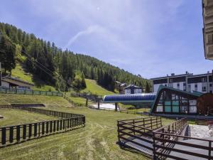 a farm with a slide and a hill with trees at Apartment Villa Adele by Interhome in Madesimo