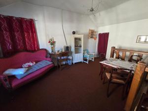 a living room with a red couch and a table at Les Pierres Du Périgord 200 in Couze-et-Saint-Front