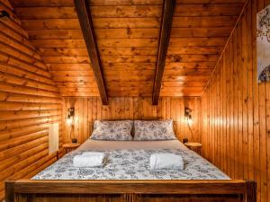 a bedroom with a bed in a wooden cabin at Chalet Cozy Bear Cabin by Interhome in Mrkopalj
