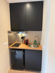 a small kitchen with a sink and a stove at Le Col Getaway Virage 5 in Le Bourg-dʼOisans