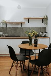 a table with a bottle of wine and flowers on it at Złota Brama - Old Town Apartment 1 in Gdańsk