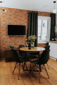a dining room with a table and chairs and a brick wall at Złota Brama - Old Town Apartment 1 in Gdańsk