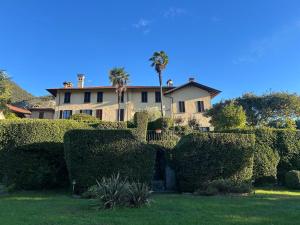a large house with a lot of bushes and trees at Casa Ninni in Tremezzo