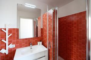 a red tiled bathroom with a sink and a mirror at A due passi da in Corato