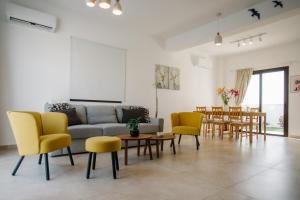 a living room with a couch and chairs and a table at Villa Kokona Private Pool Sea View in Sophtadhes